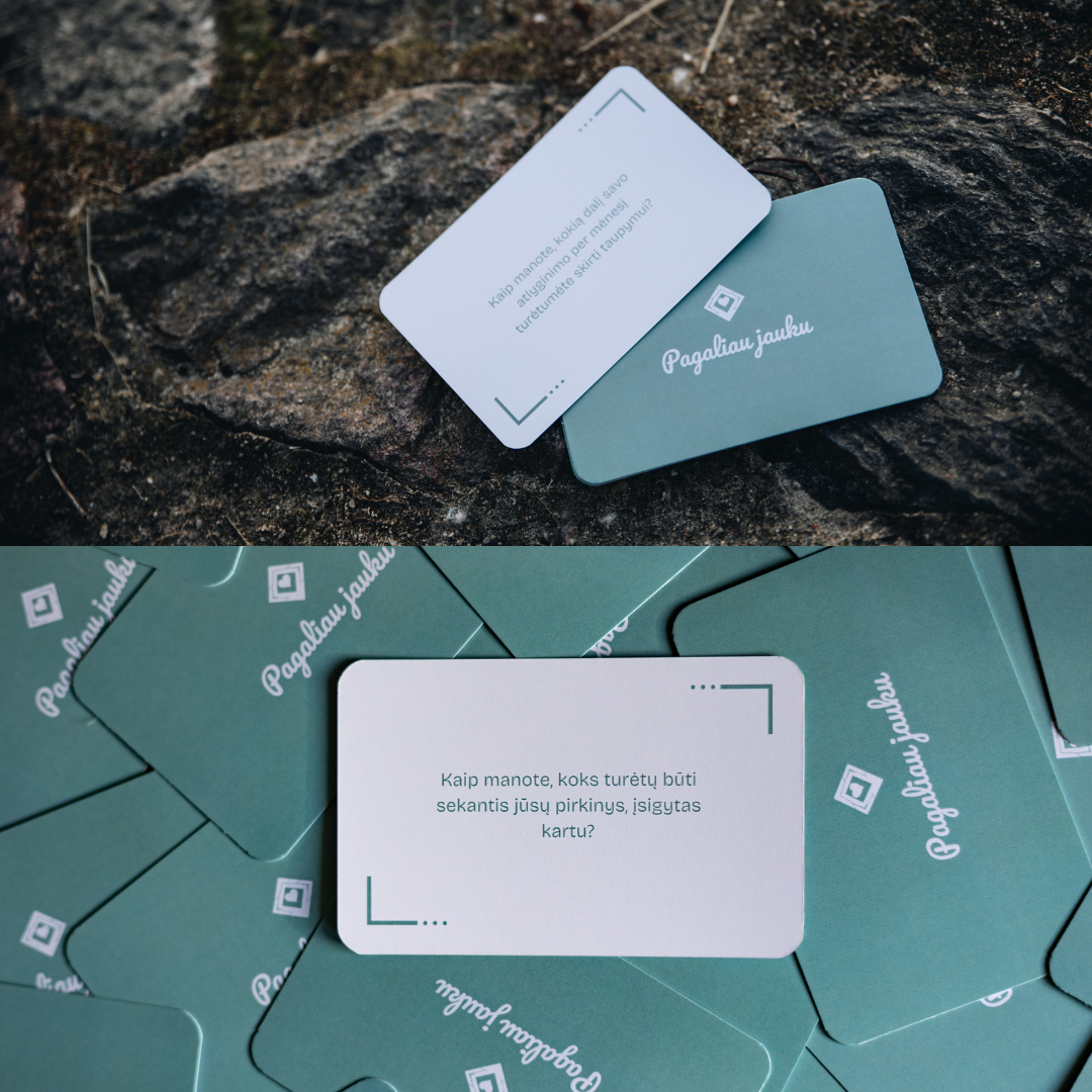 Two business cards on a textured surface with a stack of cards below.