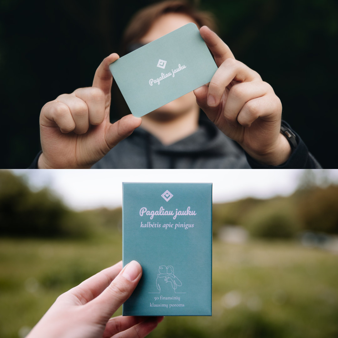 Person holding a teal card with text and a logo against a blurred natural background